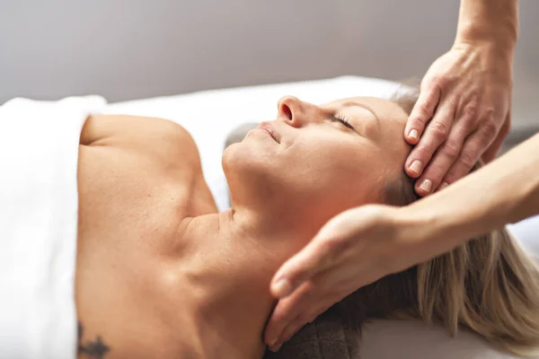 Een vrouw genieten van spa behandeling in salon met masseur werknemer — Stockfoto