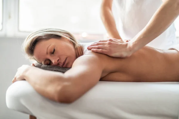 A Woman enjoying spa treatment at salon with masseur worker — Stock Photo, Image