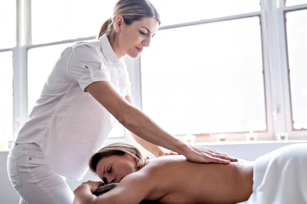 Una mujer disfrutando de un tratamiento de spa en el salón con masajista — Foto de Stock