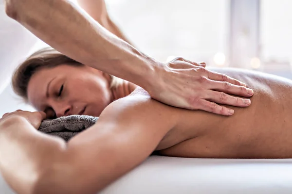 Una mujer disfrutando de un tratamiento de spa en el salón con masajista — Foto de Stock