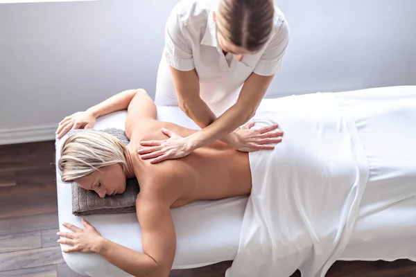 Uma mulher desfrutando de tratamento de spa no salão com massagista — Fotografia de Stock