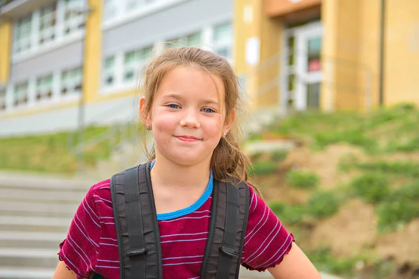 Ładny portret uroczej dziewczyny z plecakiem w szkole — Zdjęcie stockowe