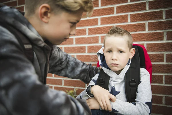 Мальчик проблема в школе, сидя и утешая ребенка друг друга — стоковое фото