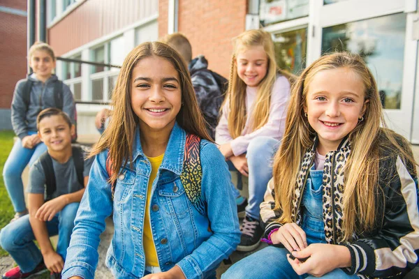 Grupo de crianças sentar nas escadas da escola se divertindo — Fotografia de Stock