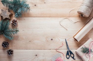 Kraft kağıdı, jute ip ve makas Noel hediyelerini paketlemek için, yeni yıl hediyeleri ve Noel hediyeleri ahşap arka planda ambalaj malzemeleri