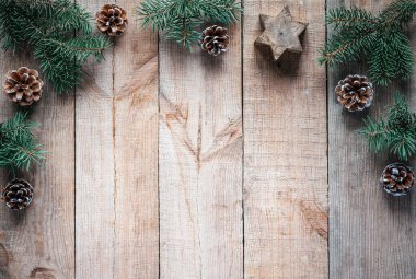 Noel ağacı dalları, çam kozalakları ve mum yıldızı ahşap arka planda fotokopi alanı ile