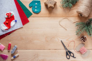 Çocuklar için keçeli süsler, Noel ağacı süslemeleri, iplik ve makaslar ahşap arka planda fotokopi alanı ile birlikte.