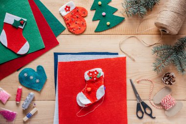 Noel çorap dikmeyi, Noel 'i ve yeni yılı çocuk el sanatlarını, ahşap arka planda keçeli süslemeleri hissetti.