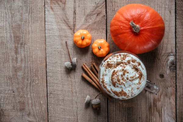 Autumn pumpkin latte on wooden background top view