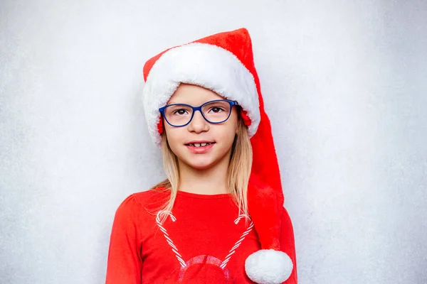 Menina feliz usando óculos e chapéu de Papai Noel durante o Natal e feriados de Ano Novo — Fotografia de Stock