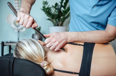 Rhomboid 'ler için IASTM aracı ile miyofasiyal tahliye teknikleri uygulayan kayropraktik uzmanı