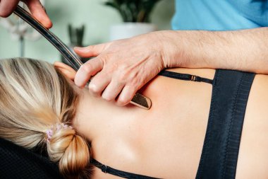 Rhomboid 'ler için IASTM aracı ile miyofasiyal tahliye teknikleri uygulayan kayropraktik uzmanı