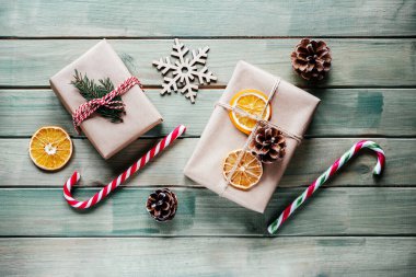 Noel hediyesi olarak şeker kamışları, kozalaklar ve ahşap arka planda kuru portakal dilimleri.