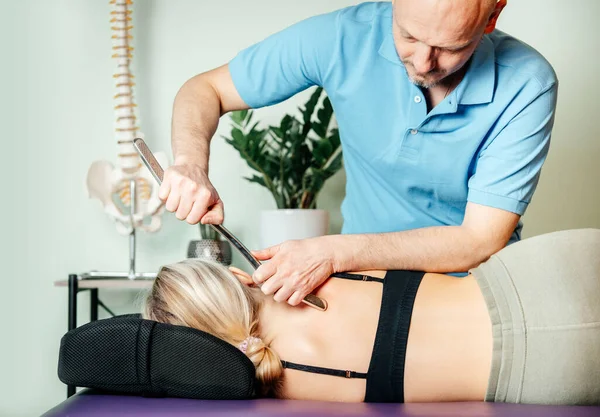 Rhomboid 'ler için IASTM aracı ile miyofasiyal tahliye teknikleri uygulayan kayropraktik uzmanı