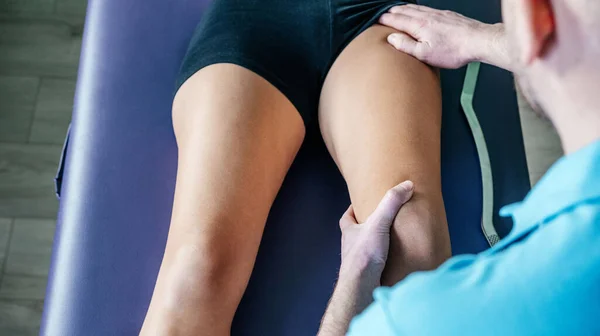 Osteopat uyluk kası kasları için miyofasiyal salınım gerçekleştiriyor.