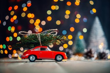 Noel ağaçları arka plan dağıtır, köknar ağacıyla kırmızı oyuncak araba renkli Noel ışıklarına karşı bokeh