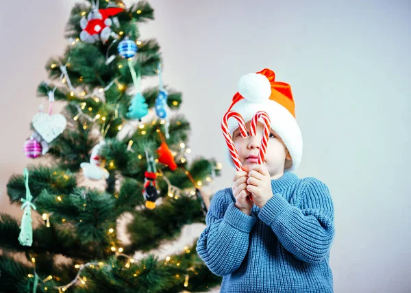 Маленький хлопчик у Санта - Капелюшці творить серцебиття з цукерок у час Різдва. — стокове фото