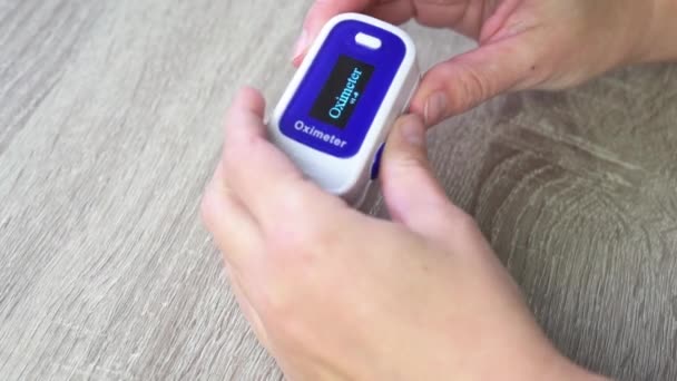 Fingertip pulse oximeter, patient measuring the blood oxygen with oximeter — ストック動画