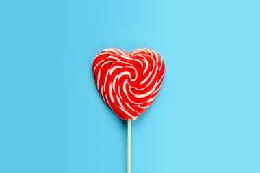 Kırmızı kalp lolipopu mavi arka planda aşk ve sevgililer günü geçmişi