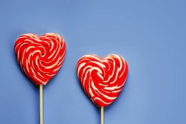 Kırmızı kalp lolipopları mor arka planda aşk ve sevgililer günü geçmişi