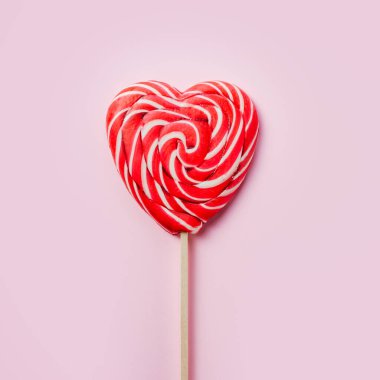 Pembe arka planda kırmızı kalp lolipopu aşk ve sevgililer günü geçmişi