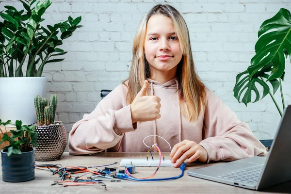 Evde robot bilimi, kök ve arduino kodlama dersleri alan genç bir kız.