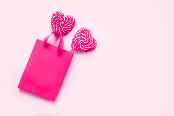 Rosa shoppingväska med två hjärtformade klubbor på rosa Alla hjärtans dag bakgrund — Stockfoto