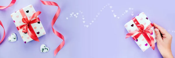 Cajas de regalo de San Valentín con corazones y cinta roja sobre fondo violeta púrpura, tamaño de la bandera —  Fotos de Stock
