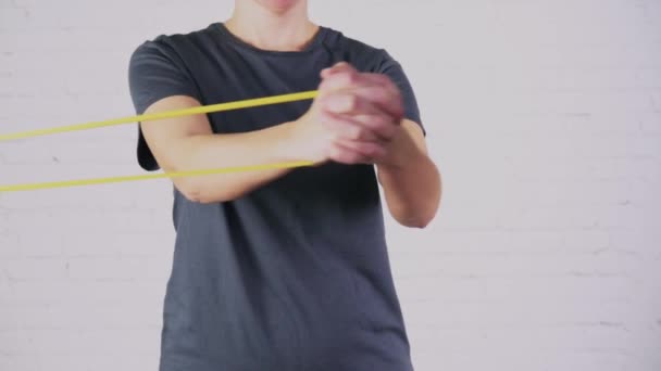 Una mujer realiza ejercicios con banda de resistencia — Vídeos de Stock