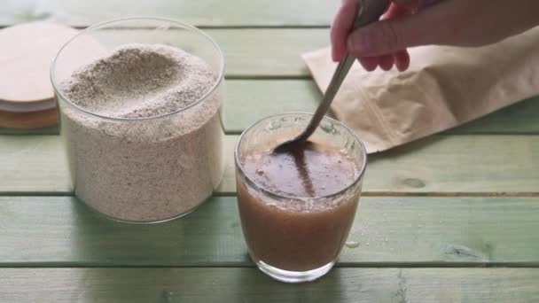 Misturando psyllium casca suplemento de fibra dietética em um copo de água para tomar pela manhã — Vídeo de Stock