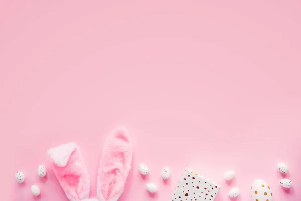 Composição de compras de Páscoa com orelhas de coelho, caixa de presente e ovos de Páscoa no fundo rosa — Fotografia de Stock