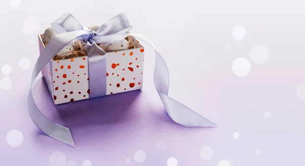 Diseño creativo de Pascua con huevos de Pascua en una caja de regalo con cintas de rubor de lavanda sobre fondo púrpura pálido —  Fotos de Stock