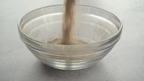 Filling a glass bowl with psyllium husk dietary fiber supplement — Stock Video
