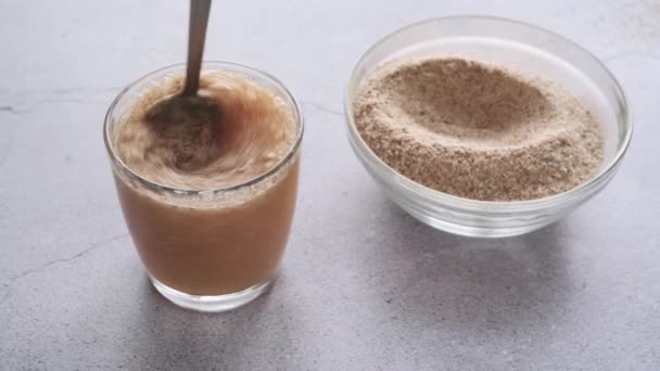 Psyllium casca suplemento de fibra dietética misturada com água em um copo — Vídeo de Stock