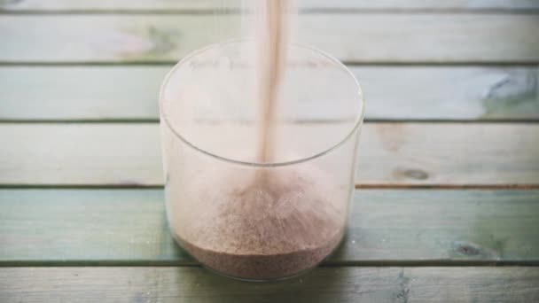 Enchendo um recipiente de vidro com casca seca Psyllium suplemento de fibra dietética — Vídeo de Stock