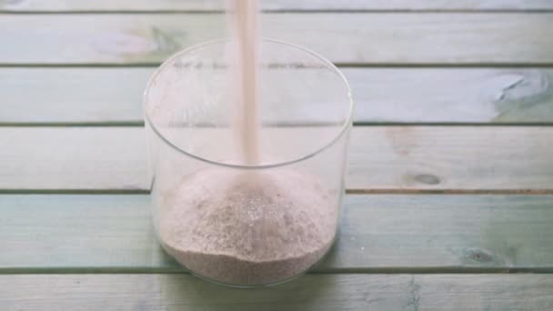 Fylla en glasbehållare med torrt Psyllium skal kostfiber tillägg — Stockvideo