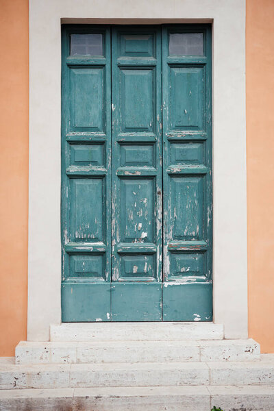 Emerald green painted wooden door in the house with coral color walls