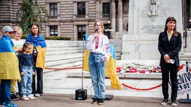 Glasgow, Scotalnd - July 30, 2022 a girl singing Ukrainian song at Anti-Russia protest with participants calling for Russia to be recognised as a terrorist state, war in Ukraine