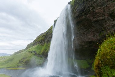 Seljalandsfoss yaz sezonunda İzlanda 'ya düşer. İzlanda manzarası.