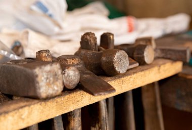 Adamın elinde bozuk bir çekiç var. Aletlerin parçalanması ve tahrip edilmesi. Güvenlik yönetmeliklerinin ihlali. Bozuk bir araç.