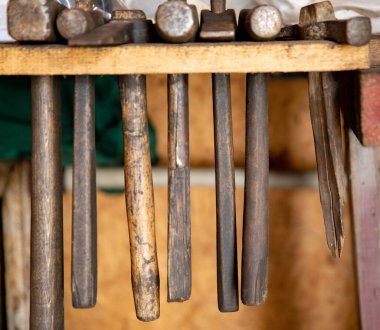 Adamın elinde bozuk bir çekiç var. Aletlerin parçalanması ve tahrip edilmesi. Güvenlik yönetmeliklerinin ihlali. Bozuk bir araç.