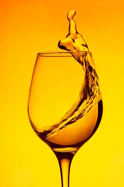 Ein Glas Wein Ein Spritzer Weinrotes Wasser Auf Gelbem Hintergrund — Stockfoto