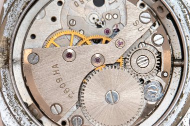 Parçalanmış durumdaki eski bir kol saati mekanizmasının makrofotoğrafçılığı.