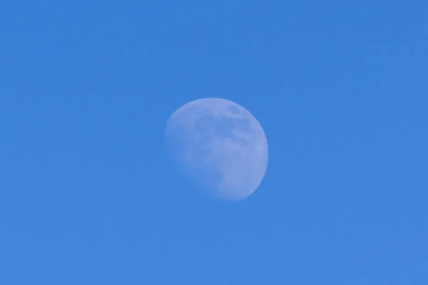 Photo of the moon in the daytime on a blue background without stars