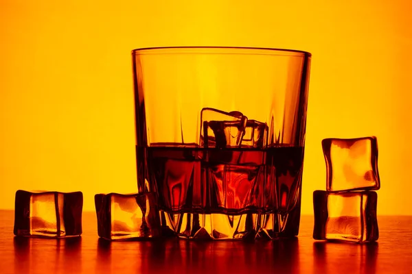 Sklenici Whisky Ledu Žlutém Pozadí Roztroušený Led Pomalu Tající Čerstvá — Stock fotografie