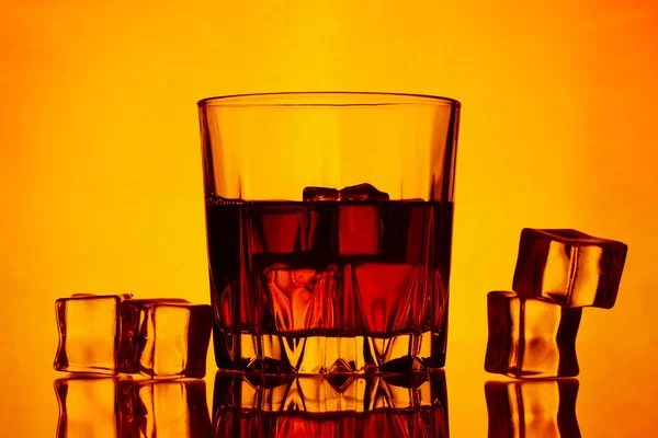 Ein Glas Whiskey Und Eis Auf Gelbem Hintergrund Verstreutes Eis — Stockfoto
