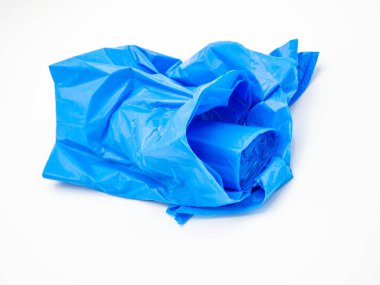 Plastik çöp torbaları toplanmış, mavi arka planda.