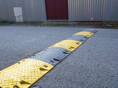 Yolda hız tümseği, asfalt yolda sarı ve siyah çizgili tümsek hızlı hareket eden arabaları yavaşlatmak için.