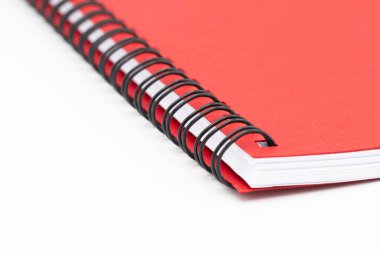 Beyaz arkaplanda kırmızı kapaklı spiral defter veya not defterini kapat