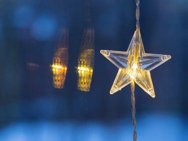 Detail of shining LED chain with stars, Christmas decoration hanging on window